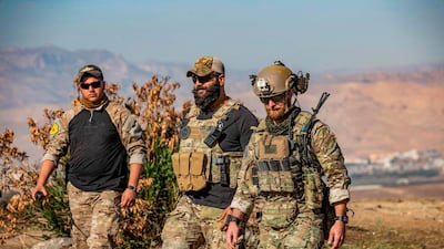 (L to R) A member of the Kurdish People's Protection Units (YPG) walks with US soldiers during a patrol in the village of Ein Diwar in Syria's northeastern Hasakeh province. AFP