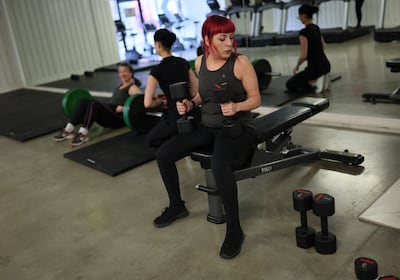 Women lift weights with during a strength circuit for women over 40, in London. Reuters