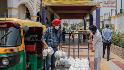 Volunteers load meals to be donated to patients across the city suffering from Covid-19, made at the Gurudwara Bangla Sahib, in New Delhi. Getty Images