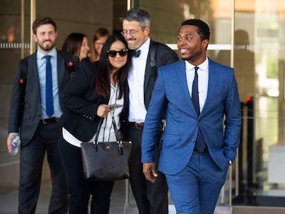 Rapper Marcus Gray, right, smiles as his attorney, Michael A. Kahn, second from right, congratulates Gray's wife, Crystal, as they leave the federal courthouse in Los Angeles (AP Photo/Damian Dovarganes)