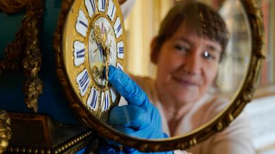 Goodwood's clock curator Su Fullwood adjusts the hands on a Sevres ormolu French mantel clock on Thursday, at Goodwood House in Chichester, as she prepares the antique collection for British Summer Time, which starts on Sunday March 27. PA