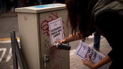 A pro-independence supporter pastes a poster calling for people to vote Yes in the planned independence referendum. AP Photo/Emilio Morenatti