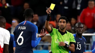 Referee Mohammed Abdulla Hassan Mohamed shows France's Paul Pogba a yellow card. Damir Sagolj / Reuters