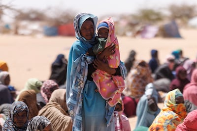 Sudanese refugees wait to be given plastic sheets and food at the Oure Cassoni camp in Chad. Getty Images