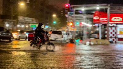 NEW YORK, NY - SEPTEMBER 01: A delivery worker makes their way in the rainfall from Hurricane Ida during a flood on Intervale Avenue on September 1, 2021, in the Bronx borough of New York City. The once category 4 hurricane passed through New York City, dumping 3. 15 inches of rain in the span of an hour at Central Park. David Dee Delgado / Getty Images / AFP