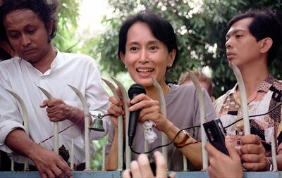 Aung San Suu Kyi addresses supporters from the main gate of her family compound in Yangon in 1995. AFP