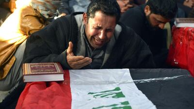 Iraqis mourn over the coffins, clad in their national flag, of the people who were reportedly abducted and killed, during their funeral in the central holy city of Najaf. AFP