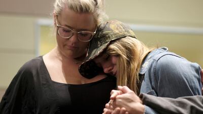 People comfort each other after a candlelight vigil for the victims of the mass shooting. AP Photo