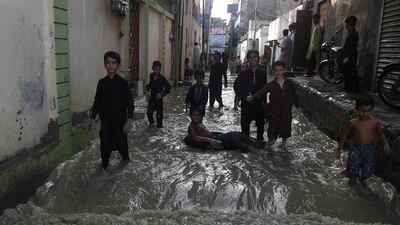Children play on a waterlogged alley after heavy monsoon rains in Karachi. AFP