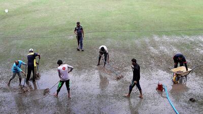 Ground staff try clearing the rain from the pitch at the Sharjah Cricket Stadium. The World Cup League 2 match between UAE vs Scotland was eventually abandoned. All photos by Pawan Singh / The National