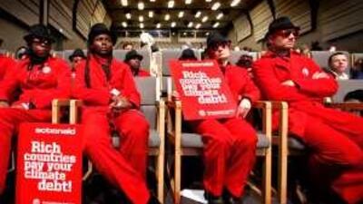 Whom do they believe? Activists from the group Actionaid attend a news conference at the Copenhagen Climate Change Conference.