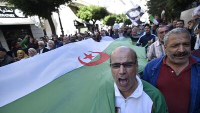 Algerian protesters rally with a huge national flag in the centre of the capital Algiers as anti-government demonstrations continue. AFP