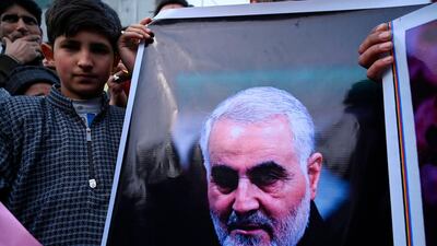 A protester holds a poster with the image of top Iranian commander Qassem Suleimani, who will be buried in his home town on Tuesday. AFP
