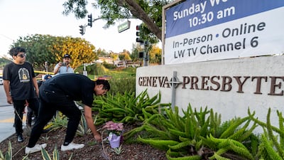 Hector Gomez and Jordi Poblete, worship leaders at the Mariners Church Irvine, leave flowers outside the Geneva Presbyterian Church in Laguna Woods, California. AP