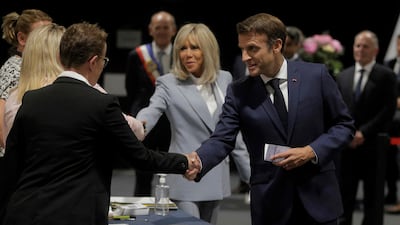 French President Emmanuel Macron and his wife Brigitte Macron arrive to vote in the second stage of French parliamentary elections at a polling station in Le Touquet, northern France, on Sunday. AFP