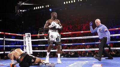 Referee Celestino Ruiz moves in to protect Shawn Porter after Porter was knocked down in the 10th round by WBO champion Terence Crawford. AFP