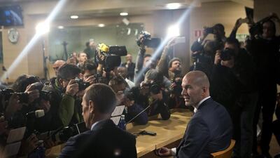 Real Madrid's newly appointed coach Zinedine Zidane, right, sits down in front of the media before his first press conference at the Santiago Bernabeu stadium in Madrid, Spain, Tuesday Jan. 5, 2016. (AP Photo/Paul White)
