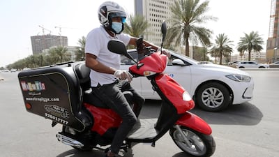 Delivery men wear protective face masks as they deliver food for customers in Riyadh, Saudi Arabia. Reuters