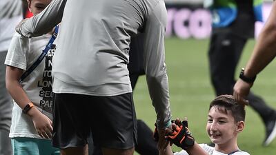 Mohamed Salah plays football with a child at the end of a training session. AFP