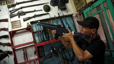 A shopkeeper in Cipacing, Indonesia, checks the weapon of a customer who brought his air rifle in for repair. Ed Wray / Getty Images