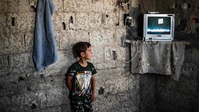 A Syrian boy, displaced with his family from Deir Ezzor, watches inside the damaged building where he is living in Syria's northern city of Raqqa.