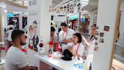 A Korean digital artist draws a caricature at her stand