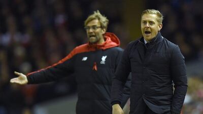 Liverpool manager Jurgen Klopp, left, and Swansea City' manager Garry Monk gesture from the touchline during their English Premier League match at the Anfield stadium in Liverpool, north-west England on November 29, 2015. AFP PHOTO / PAUL ELLIS