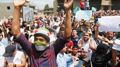 A Syrian refugee wearing a scarf in the colours of the Free Syrian Army flag during a protest in Tripoli on Sunday against Syria's presidential election. Omar Ibrahim / AP