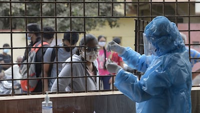 A health worker collects a swab sample from a woman to test for the coronavirus at a community hall in Hyderabad. AFP