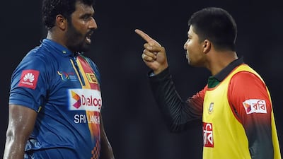 Bangladesh's Nurul Hasan, right, speaks with Sri Lanka captain Thisara Perera following the end of their Twenty20 tri-nation's match at the R Premadasa Stadium in Colombo. Ishara S Kodikara / AFP