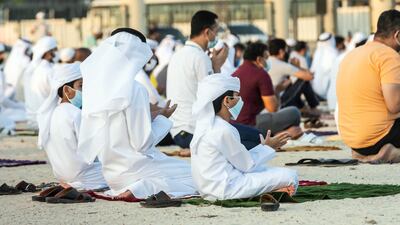 Younger worshippers wear facemasks while performing Eid prayers in Umm Suquim. Antonie Robertson / The National.
