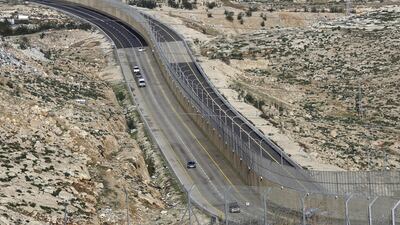 The highway features a large concrete wall segregating Israeli and Palestinian traffic. AP