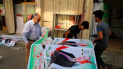 Iraqis prepare an election banner in Baghdad as the country prepares to head to the polls in May. Karim Kadim/ AP