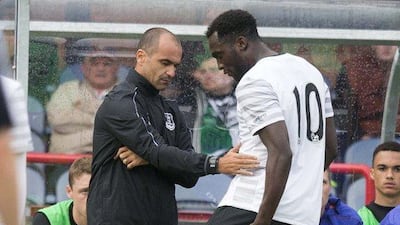 Romelu Lukaku goes off injured and shows his injury to manager Roberto Martinez . Jeff Holmes / Getty Images