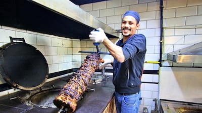 Abed pulls the piping hot meat from the oven after several hours of cooking. Courtesy Charlie Faulkner