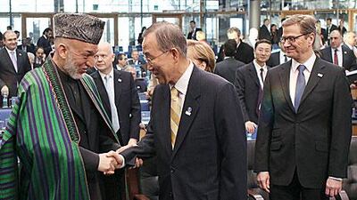 The president of Afghanistan Hamid Karzai, left, shakes hands with the UN secretary general, Ban Ki-moon. Karzai says his country will need help “for at least another decade”.