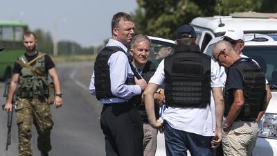 Alexander Hug, front centre, deputy head for the Organisation for Security and Cooperation in Europe's monitoring mission in Ukraine, stands with members of his team on the way to the site in eastern Ukraine. The team turned back after speaking to rebels on their way to the site. Sergei Karpukhin/Reuters