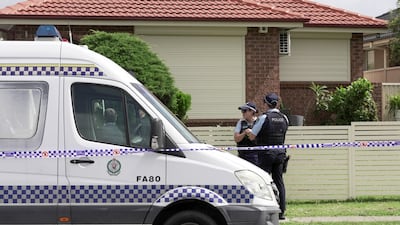 Police officers stand guard outside the house of a suspect. Reuters