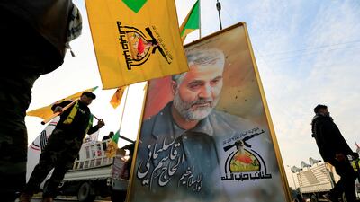 Members of the pro-Iran Kataib Hezbollah militia with a picture of the late Iranian general Qassem Suleimani in 2020. Reuters