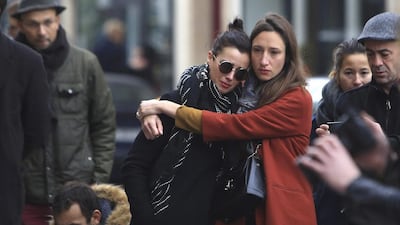 Women comfort each other as they stand in front of the Carillon cafe, in Paris. Thibault Camus / AP Photo