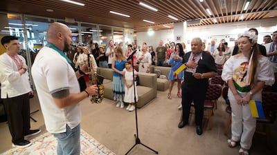 Ukrainian residents sing their national anthem on Saturday to mark 33 years since independence from the Soviet Union
