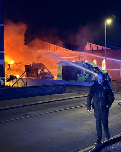 Firefighters tackle flames from ambulances after the arson attack. PA