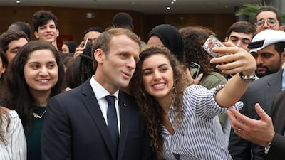French President Emmanuel Macron poses for selfies with students at Paris-Sorbonne University Abu Dhabi. Ludovic Marin / AFP Photo