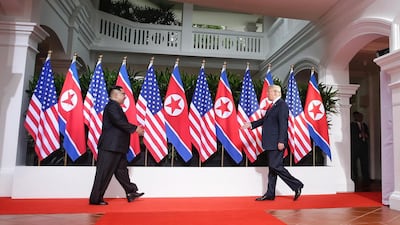 US President Donald Trump (R) and North Korean leader Kim Jong-un (L) walk towards each other to shake hands at the start of a historic summit at the Capella Hotel on Sentosa Island, Singapore, on June 12, 2018. Kevin Lim / EPA