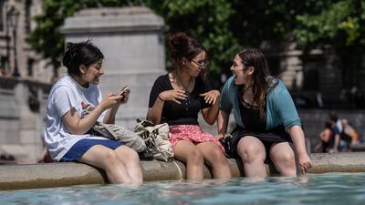 Women enjoy the afternoon sun in Trafalgar Square in London. Getty Images
