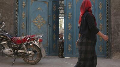 An Uighur woman walks in a residential area in turpan, Xinjiang. China's claims that it is fighting an Islamist insurgency in energy-rich Xinjiang - a vast area of deserts, mountains and forests - are not new. Michael Martina / Reuters