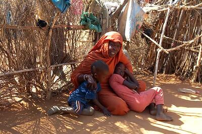 A displaced Sudanese mother with her children sit on the ground in the famine-stricken Zamzam camp in northern Darfur, Sudan. AFP