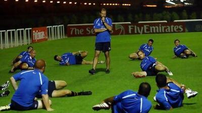 Bruce Birtwistle, the outgoing UAE coach, standing, looks on as his team train at The Sevens in Dubai. Satish Kumar / The National