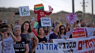Demonstrators hold up signs as they gather for a demonstration for coexistence between Jews and Arabs in the town of Rosh Pinna in northern Israel on May 13, 2021. AFP