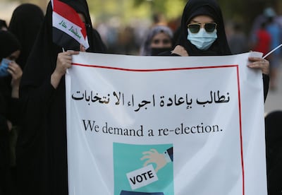Iraqi supporters of the pro-Iran Hashed Al Shaabi alliance wave national flags during a protest to denounce the results of Iraq's parliamentary elections. AFP